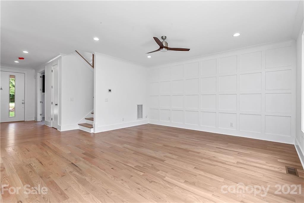 3909 Plainview Road Charlotte, NC 28208 - Photo 6 of 24 a view of an empty room with wooden floor and a ceiling fan