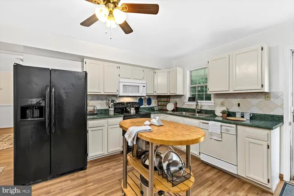 a kitchen with stainless steel appliances granite countertop a stove refrigerator sink and cabinets