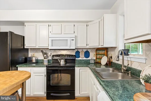 a kitchen with granite countertop a sink a stove and a granite counter top