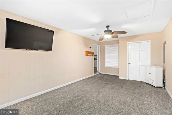 a view of a livingroom with an empty space and a ceiling fan