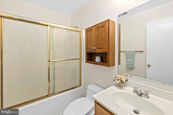 a bathroom with a sink mirror vanity and toilet