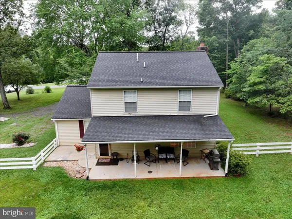 an aerial view of a house with patio and a yard