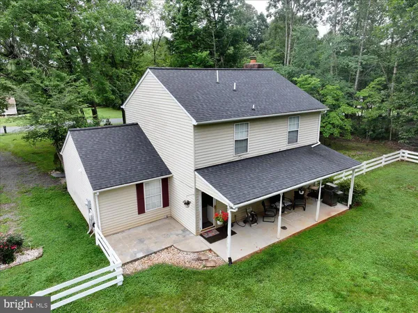 a aerial view of a house with a yard and large trees