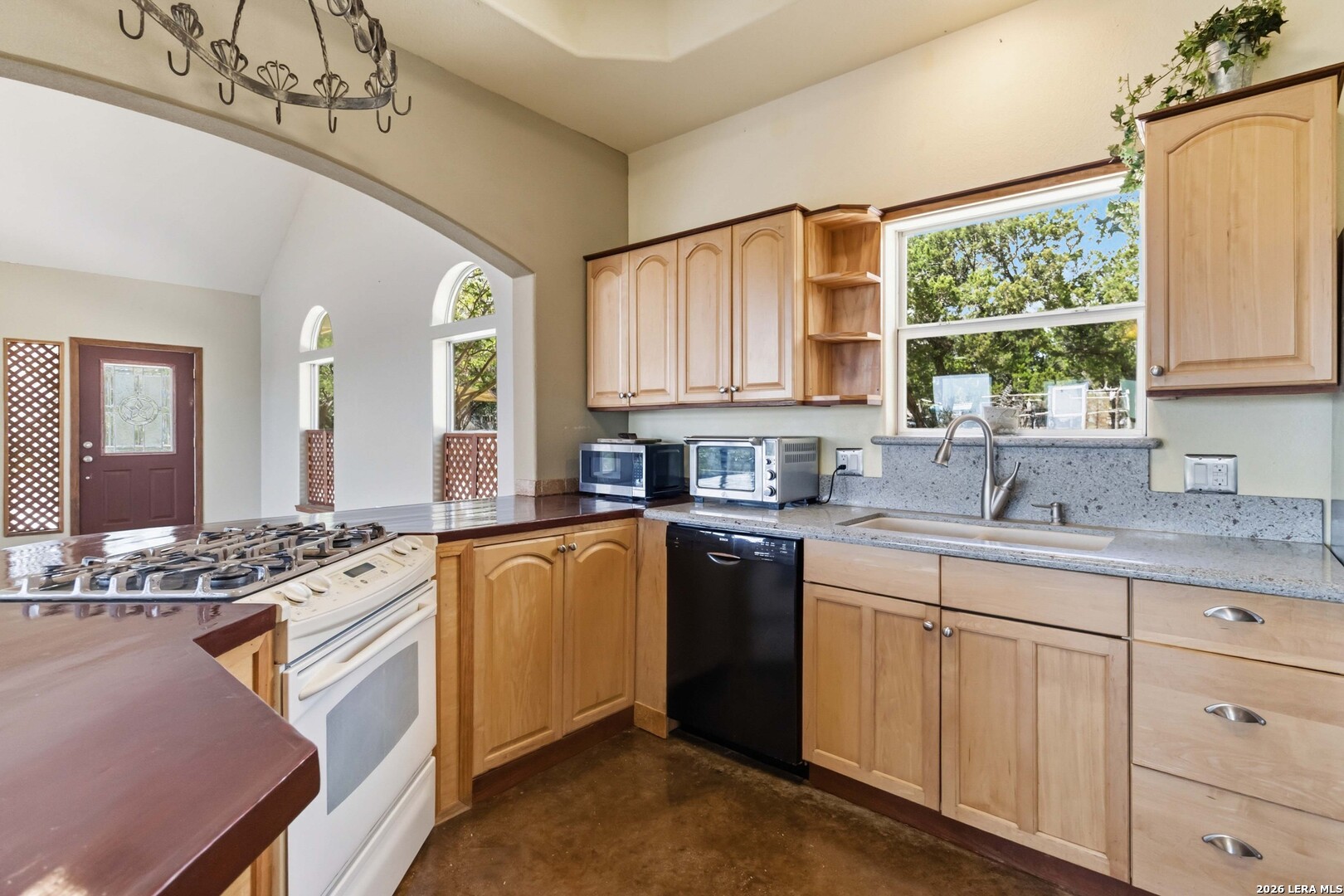 19708 Nottingham Lane Grey Forest, TX 78023 - Photo 27 of 67 a kitchen with stainless steel appliances kitchen island granite countertop a sink a stove a counter space and a window