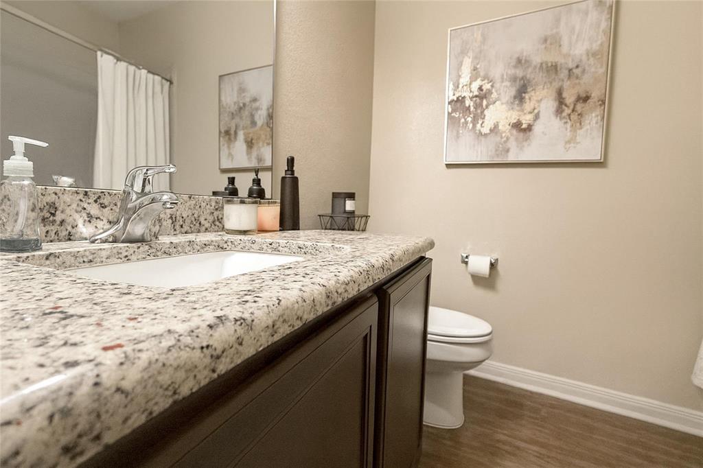 1837 Rialto Lane Crowley, TX 76036 - Photo 13 of 19 Bathroom vanity featuring a polished chrome faucet, an undermount sink, and a speckled countertop