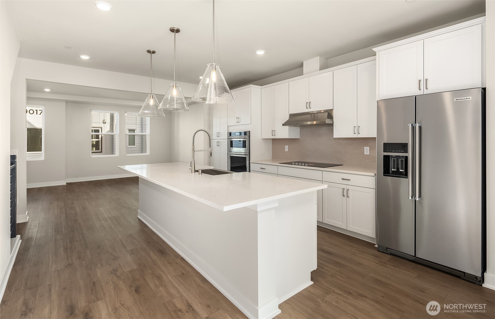 1004 243rd Place Southeast, Unit B Bothell, WA 98021 - Photo 2 of 18 a large kitchen with stainless steel appliances a refrigerator a sink dishwasher a stove and white cabinets with wooden floor