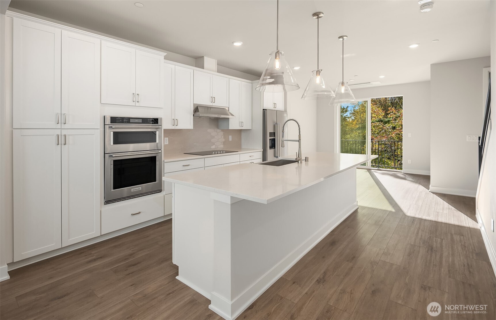1004 243rd Place Southeast, Unit B Bothell, WA 98021 - Photo 3 of 18 a large kitchen with stainless steel appliances kitchen island granite countertop a stove a sink a refrigerator a center island and wooden floor