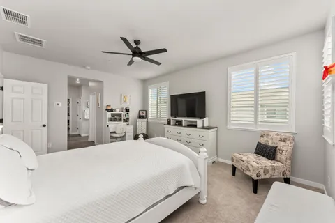 a bedroom with a bed and a flat tv screen on the dresser