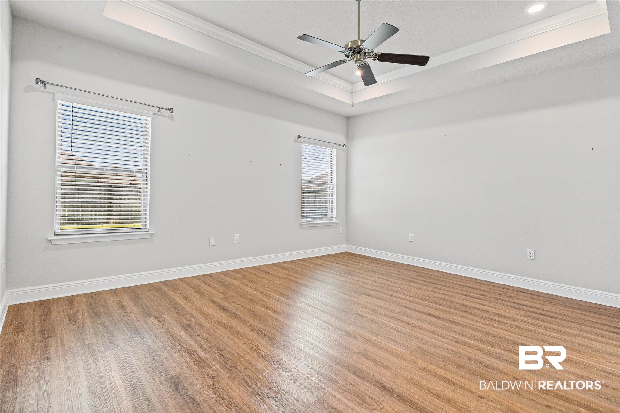 10207 Dunleith Loop Daphne, AL 36526 - Photo 8 of 23 Unfurnished room with a raised ceiling, light wood-type flooring, ornamental molding, a ceiling fan, and recessed lighting
