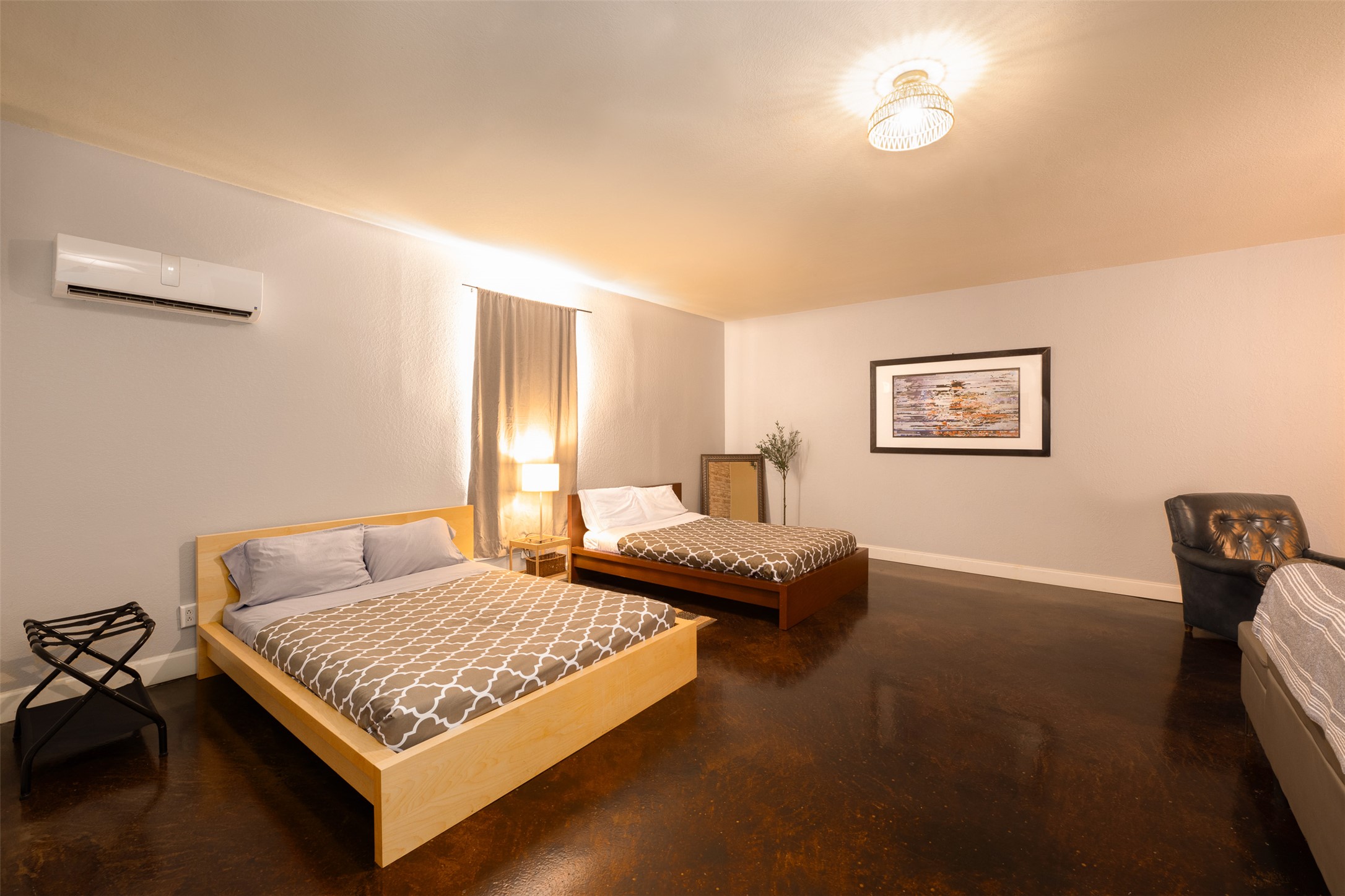 2302 East 9th Street Austin, TX 78702 - Photo 12 of 31 Richly stained concrete flooring grounds a well-lit bedroom offering comfortable repose.
