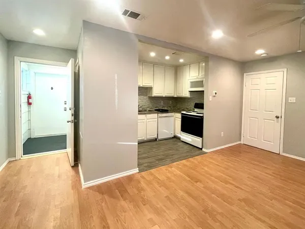 a view of a kitchen with a sink and dishwasher a refrigerator with wooden floor