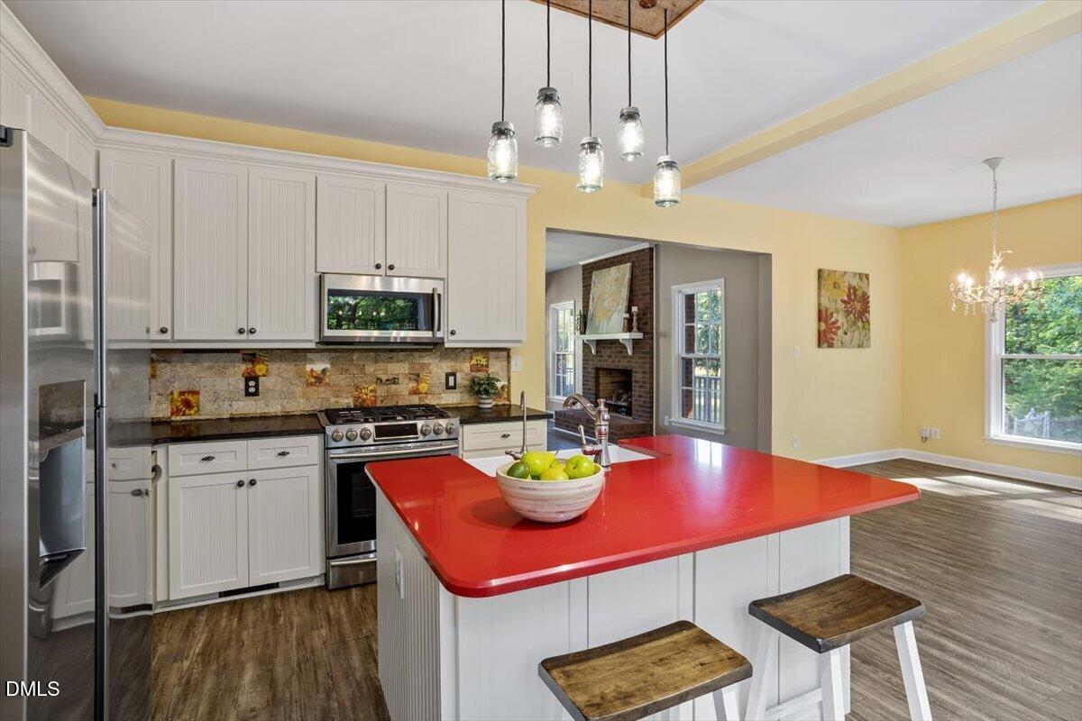 7505 Penny Road Raleigh, NC 27606 - Photo 19 of 35 a kitchen with stainless steel appliances granite countertop a stove refrigerator sink and cabinets