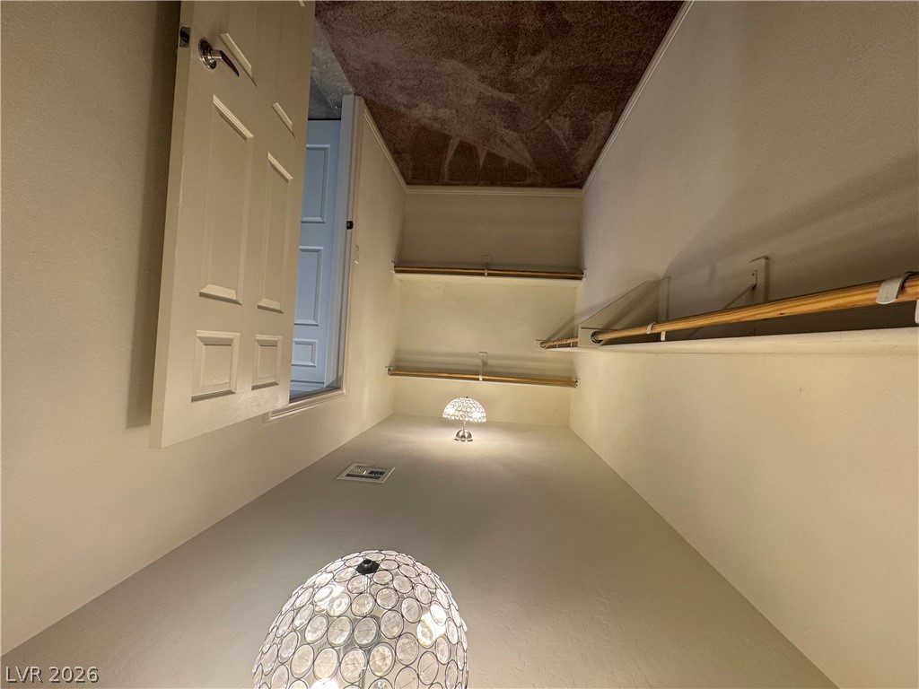 55 Canopus Ridge Way Las Vegas, NV 89183 - Photo 27 of 53 Ample storage awaits in this walk-in closet featuring plush carpeting and built-in shelving.