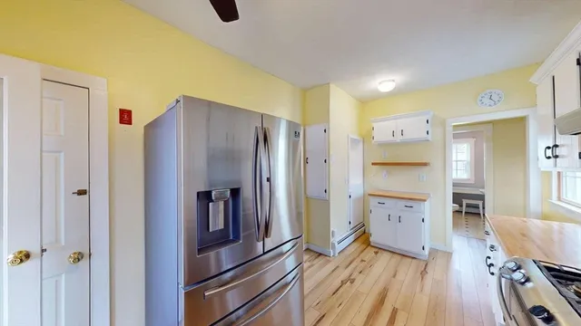 a kitchen with stainless steel appliances a refrigerator and wooden floor