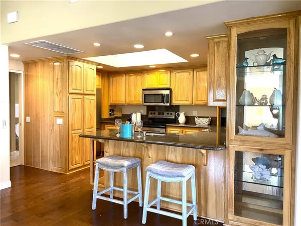 a kitchen with stainless steel appliances granite countertop a refrigerator and wooden cabinets