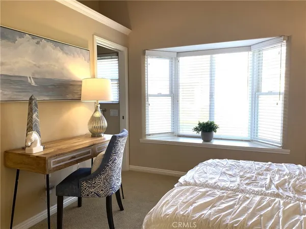 a bedroom with a bed and a lamp next to a window