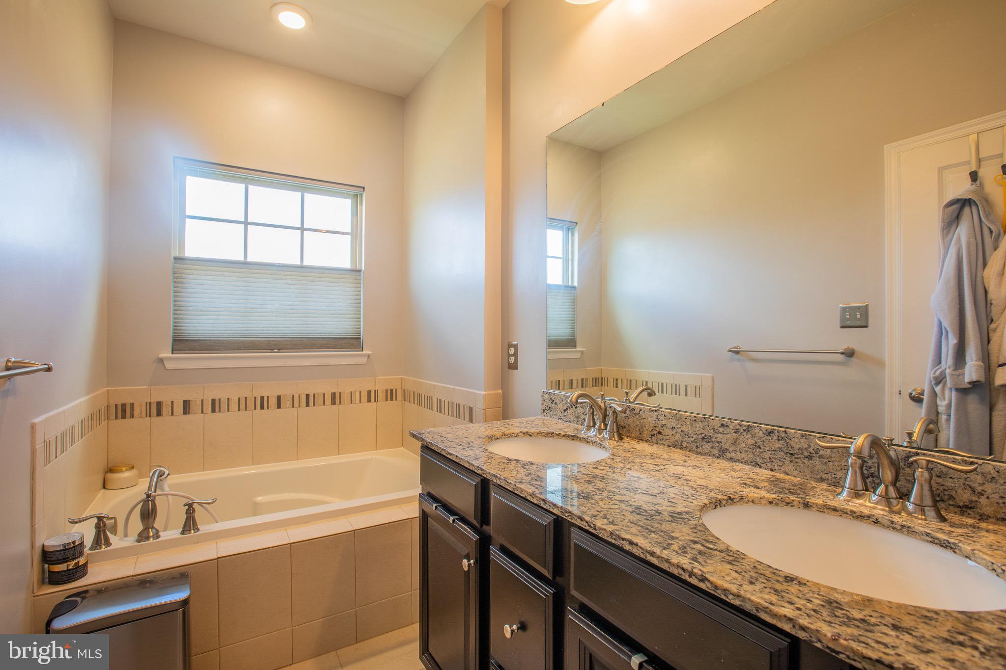 2608 Fiat Drive Hanover, MD 21076 - Photo 32 of 39 a bathroom with a granite countertop tub sink and mirror