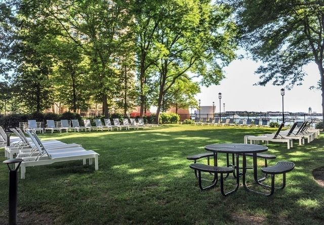 a view of a swimming pool and lounge chairs in back yard