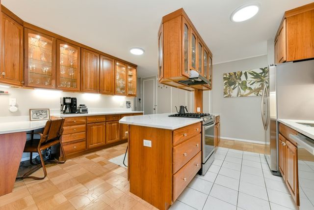 a kitchen with stainless steel appliances granite countertop a stove a sink and a refrigerator