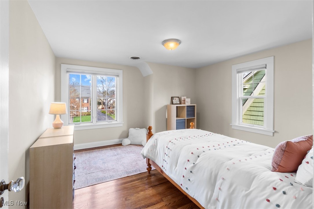 3124 Warrington Road Cleveland, OH 44120 - Photo 22 of 36 Bedroom with wood finished floors, visible vents, baseboards, and multiple windows