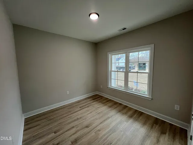 a view of a room with wooden floor and windows