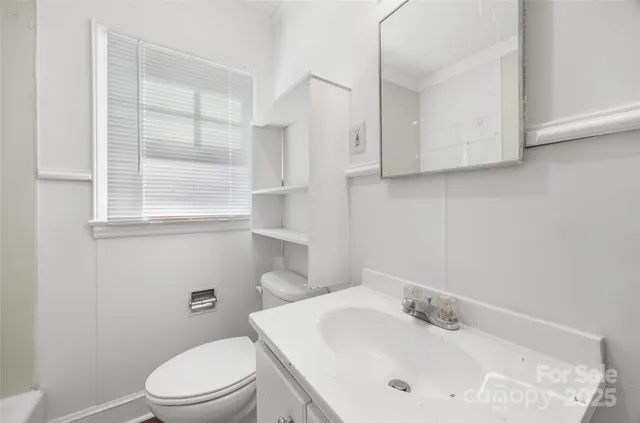 a bathroom with a sink a toilet and a window