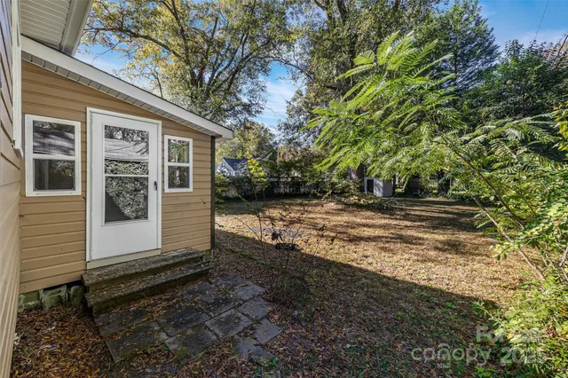 a view of a house with backyard and trees