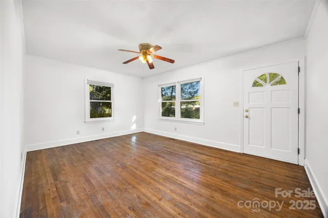 an empty room with windows and wooden floor