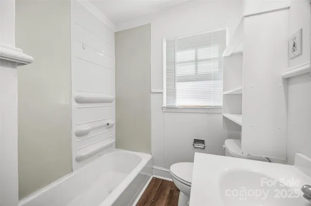 a white toilet sitting next to a bathroom sink