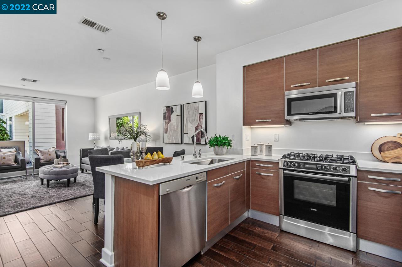 555 Ygnacio Valley Road, Unit 107 Walnut Creek, CA 94596 - Photo 1 of 1 a kitchen with a stove top oven a sink dishwasher a dining table and chairs with wooden floor