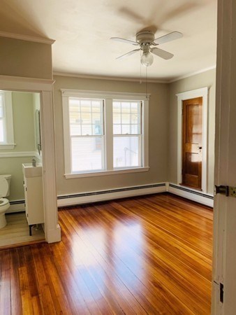 52 Powder House Boulevard, Unit 1 Somerville, MA 02144 - Photo 11 of 30 a view of empty room with wooden floor and fan