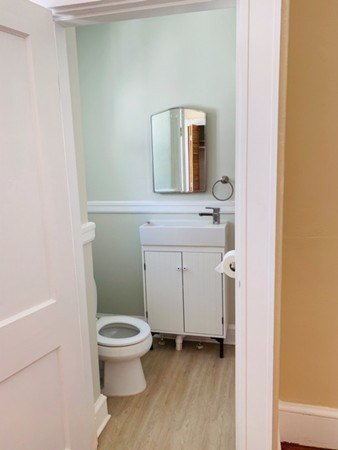 52 Powder House Boulevard, Unit 1 Somerville, MA 02144 - Photo 12 of 30 a bathroom with a toilet a sink and mirror