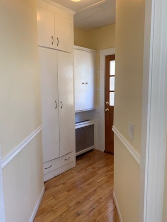 52 Powder House Boulevard, Unit 1 Somerville, MA 02144 - Photo 18 of 30 a view of a kitchen with wooden floor and electronic appliances
