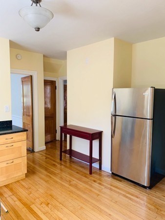 52 Powder House Boulevard, Unit 1 Somerville, MA 02144 - Photo 21 of 30 a view of kitchen with stainless steel appliances granite countertop a refrigerator and a stove top oven