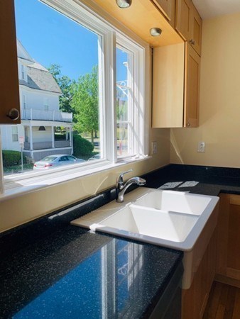 52 Powder House Boulevard, Unit 1 Somerville, MA 02144 - Photo 23 of 30 a kitchen with a sink and a window