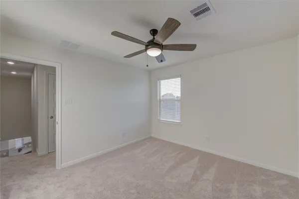 en empty room with windows and fan