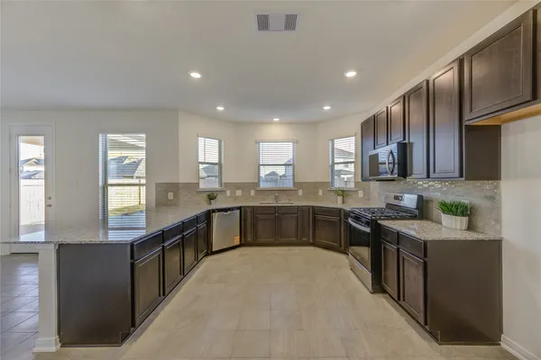 a large kitchen with stainless steel appliances lots of counter top space