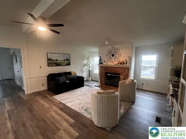 a living room with furniture a fireplace and a flat screen tv