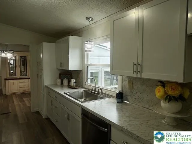 a kitchen with granite countertop a sink a stove and cabinets