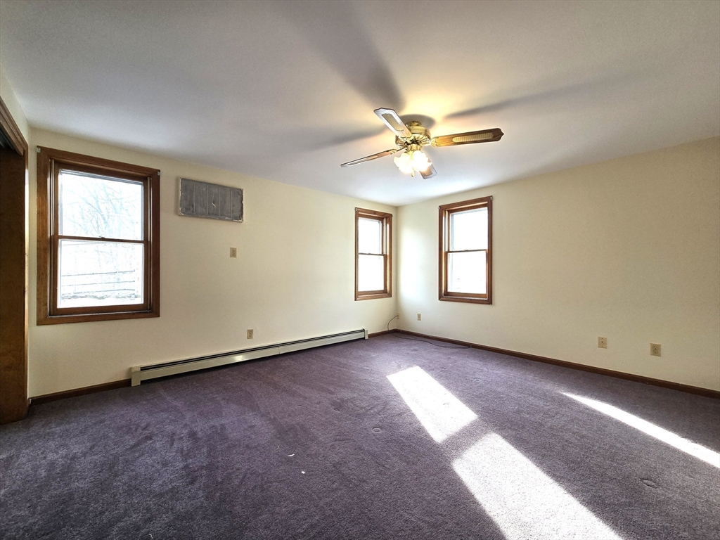 1170 Wilson Road, Unit 1 Fall River, MA 02720 - Photo 13 of 25 an empty room with windows and ceiling fan