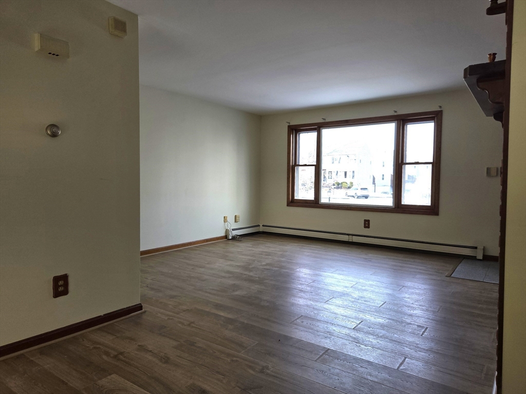 1170 Wilson Road, Unit 1 Fall River, MA 02720 - Photo 7 of 25 an empty room with wooden floor and windows
