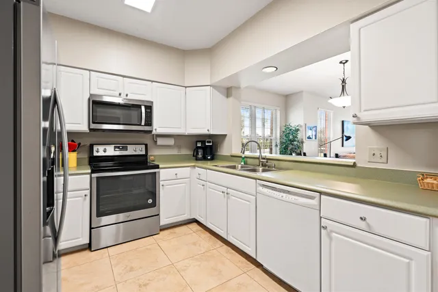 a kitchen with kitchen island granite countertop white cabinets and white appliances
