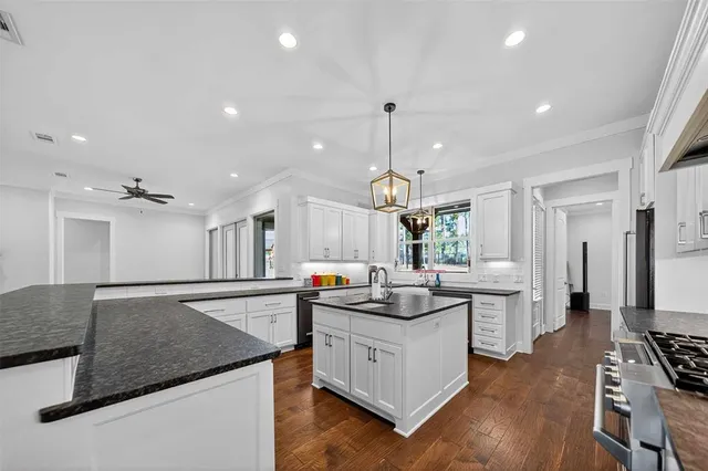 a dining hall with stainless steel appliances granite countertop a stove refrigerator and a fireplace with wooden floor