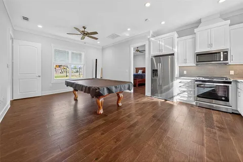 a dining hall with stainless steel appliances granite countertop a stove refrigerator and a fireplace with wooden floor