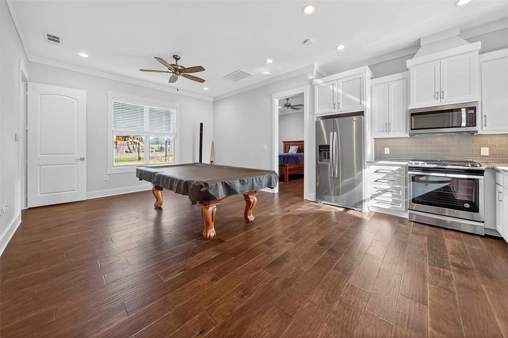 22227 Mallards Cove Bullard, TX 75757 - Photo 17 of 39 a dining hall with stainless steel appliances granite countertop a stove refrigerator and a fireplace with wooden floor