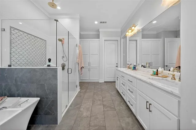 a bathroom with a double vanity sink a large mirror and shower