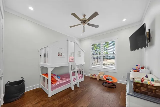 a bedroom with furniture a flat screen tv and a window