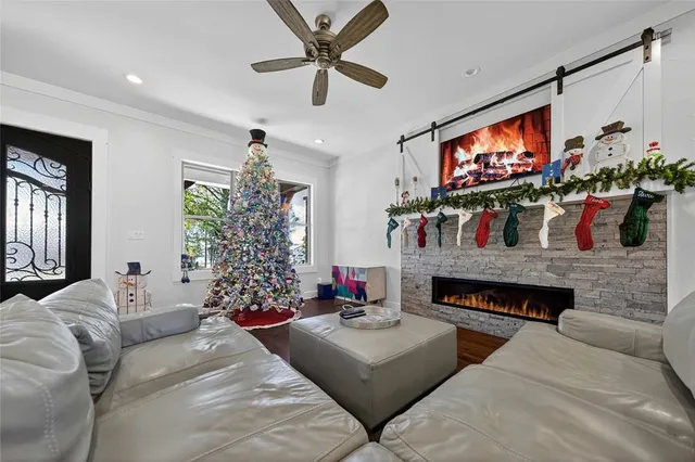 a living room with fireplace furniture a flat screen tv and a large window
