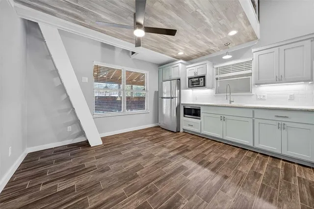 a large kitchen with stainless steel appliances granite countertop a stove a sink and a refrigerator