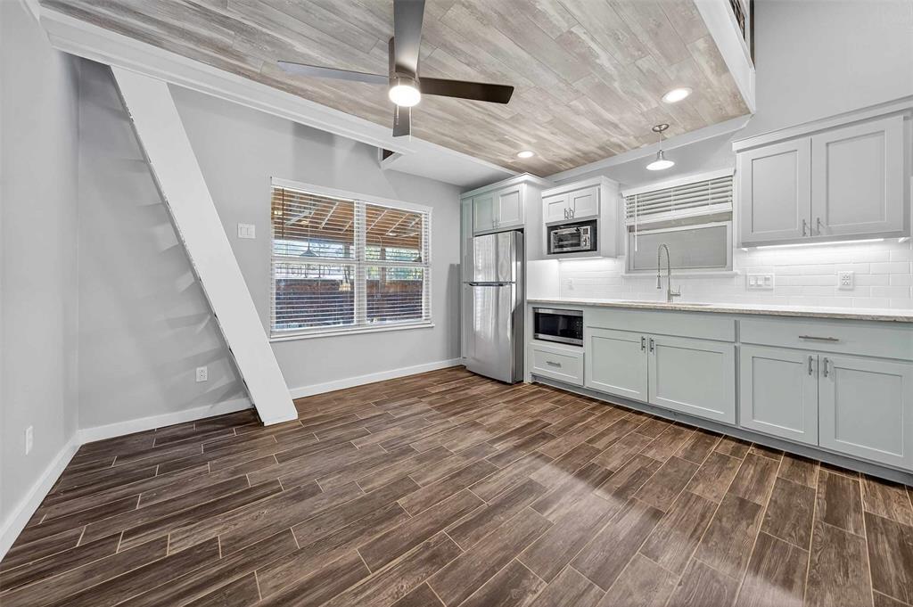 22227 Mallards Cove Bullard, TX 75757 - Photo 30 of 39 a kitchen with cabinets and wooden floor
